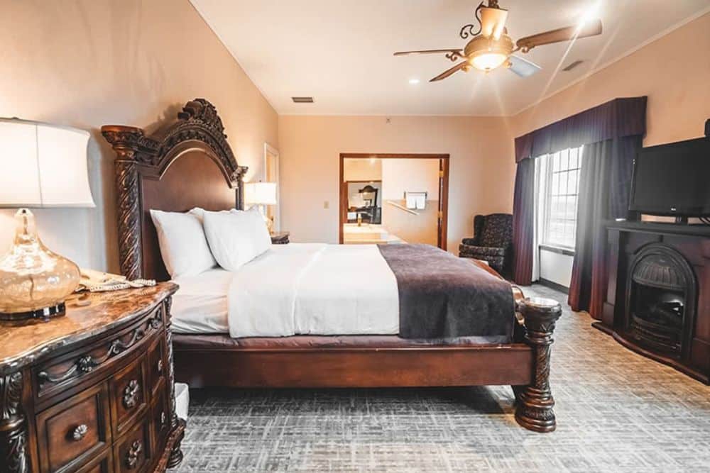 A photo of the Crowne Suite with a large dark wood furniture and new carpeting