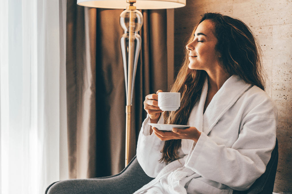 woman relaxing in hotel room drinking coffee